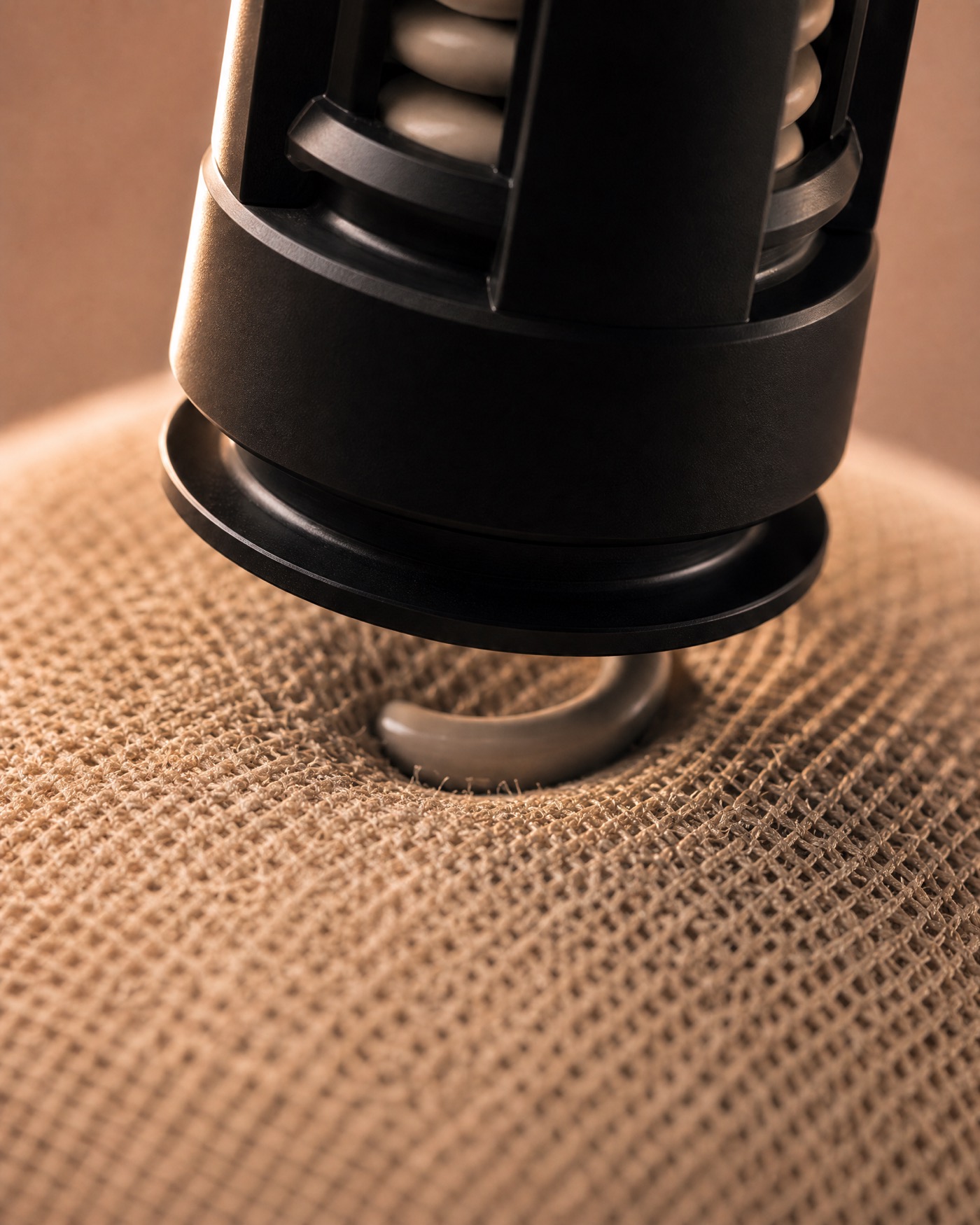 The Syn-R1 electrode resting on woven fabric, its spring visible against the weave